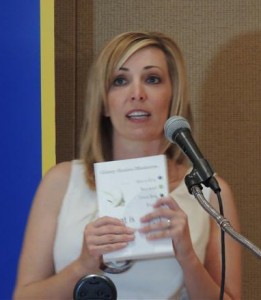Carrie Ludke holds the book written by her guest and today's speaker, Ginny Scales-Mederios