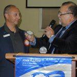 President Jose presenting a blue badge to Matthew Henry