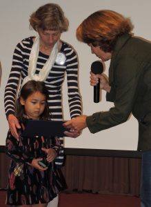 Judy Glenn’s granddaughter receiving her Paul Harris certificate from Kim Graves.